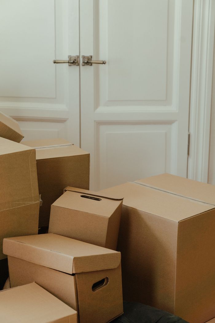 creative-01 Cardboard boxes stacked in an apartment, signifying a move-in or relocation process.