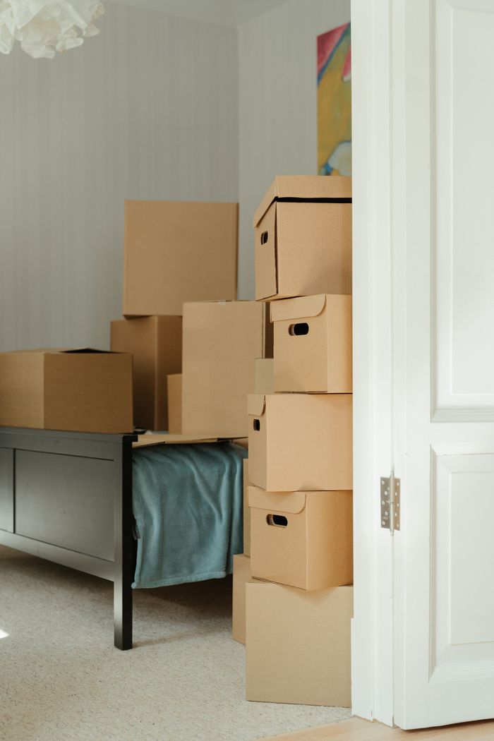 creative-03 Cardboard boxes stacked in a bedroom, symbolizing a move or relocation.